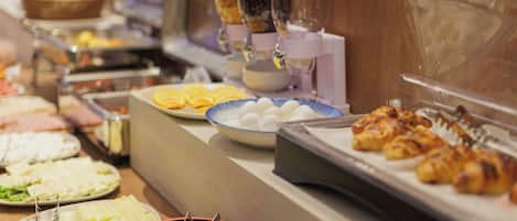 A buffet with various food items including eggs, meats, and vegetables.