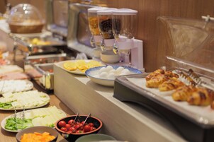 Un bufé con diversos alimentos, incluyendo huevos, carnes y verduras.