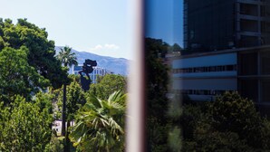 A view of a building with a modern architectural design, surrounded by lush greenery and palm trees. - Sazani Hotel (Vlorë)