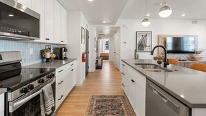 A modern kitchen with a central island, stainless steel appliances, and pendant lighting. - Mane Stay At Terra 3 Bedroom Condo (Hurricane)