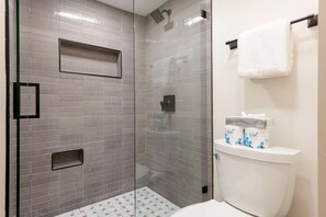 A modern bathroom with a glass-enclosed shower, a toilet with a tissue box, and a towel rack. - Stylish 4BR Canyons Village-Walk to Cabriolet-Hidden Creek 37D (Park City)
