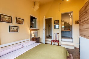 Une chambre à coucher avec un lit, une chaise, une table de chevet et une fenêtre.