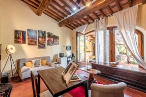 Une pièce chaleureuse avec un plafond en bois, un canapé, une table à manger et une vue sur l’extérieur.