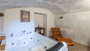 Una spa con vasca da bagno ampia, panche di legno e un quadro incorniciato appeso al muro.