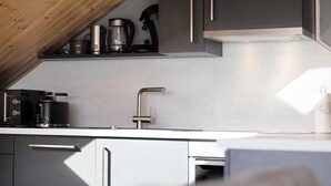 Una cucina moderna con elettrodomestici in acciaio inossidabile, forno integrato e un rubinetto dal design elegante.
