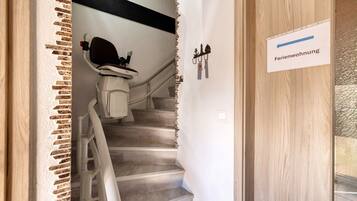 A staircase leading to a room labeled 'Ferienwohnung' with a white wall and a wooden door.