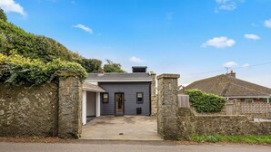 A two-story house with a stone entrance, a garage, and a small garden area. - ELEVATED ESCAPE - 3 bedroom house with rooftop terrace,sauna,hot tub&cinema room (Hythe)