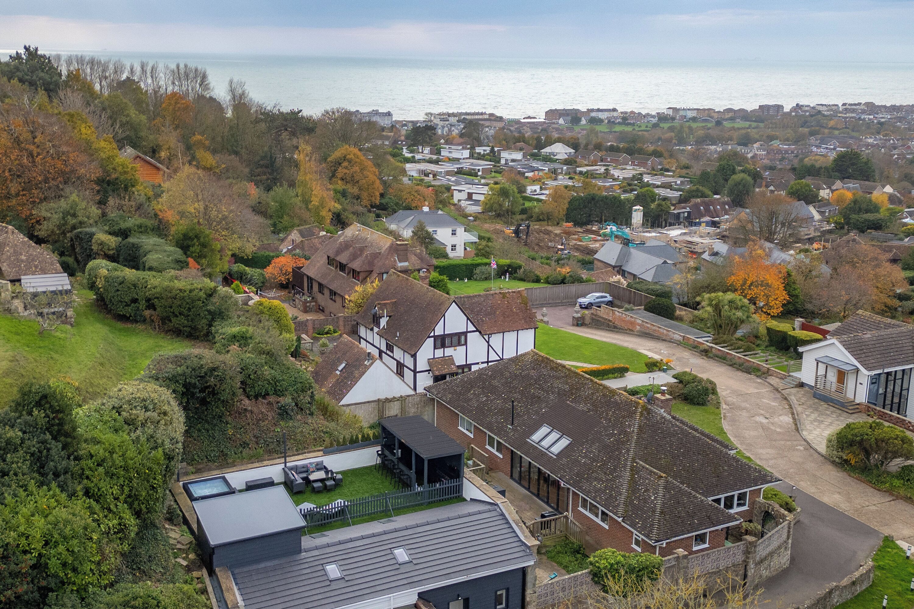 A residential area with houses, a small park, and a view of the sea.