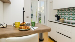 Een keuken met een houten aanrecht, een witte stoel en een deur naar een balkon.