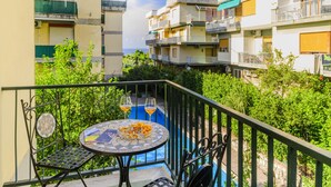 Een balkon met een ronde tafel, twee stoelen en twee glazen jus d'orange.