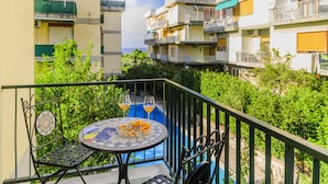 A balcony with a round table, two chairs, and two glasses of orange juice. - Estate4home - Casa Anna 1944 (Sorrento)