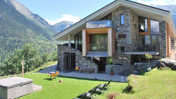 A modern house with stone and wood exterior, large windows, and a balcony. - Mineral Lodge - Les Arcs Paradiski (villaroger)