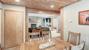 A dining area with a wooden table and chairs, a bench, and a fireplace in the background. - Summit Lodge (Fairplay)