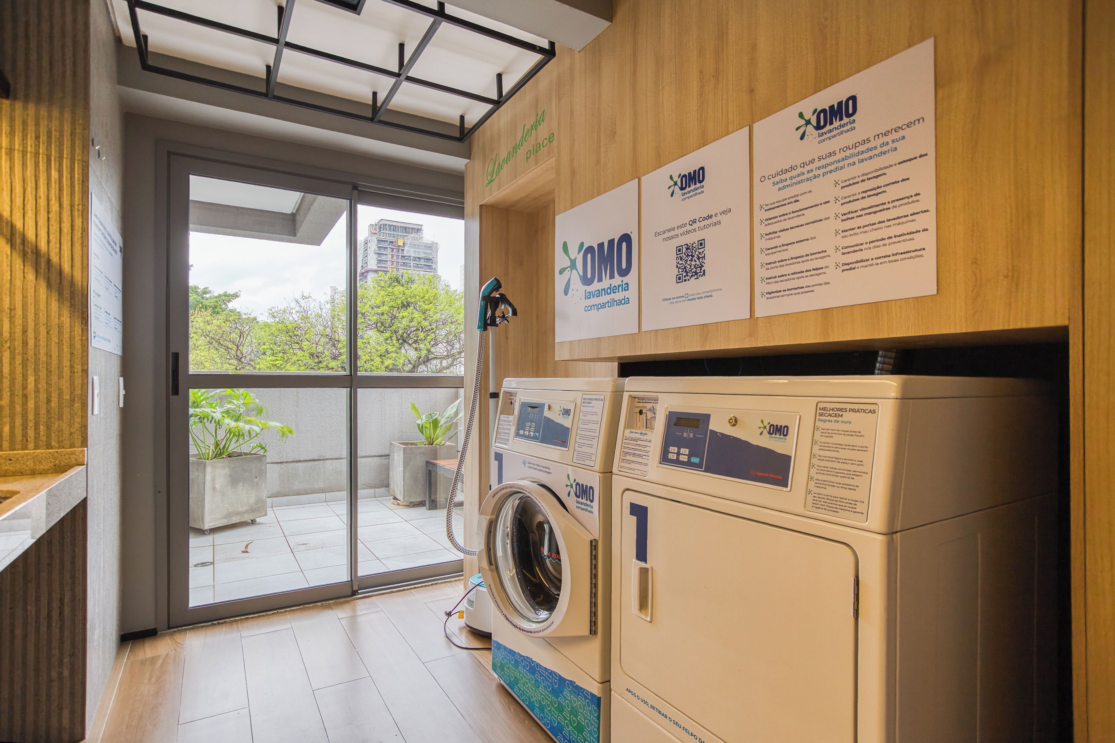 A laundry room with a large window, a washing machine, and informational posters.