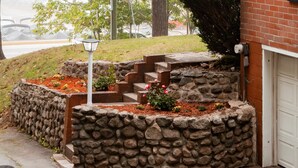 A stone retaining wall with steps leading up to a garage door. - Naples Village Retreat - Heart of the Lakes Region (Naples)