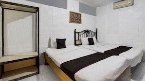 A bedroom with two beds, a bench, and an air conditioning unit. - Hotel O Near Tugu Yogyakarta 1 formerly Crown Residence (Yogyakarta)