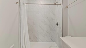 Un baño con ducha, inodoro y bañera.