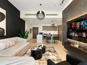 A modern living room with a sofa, coffee table, and a TV displaying Netflix content.