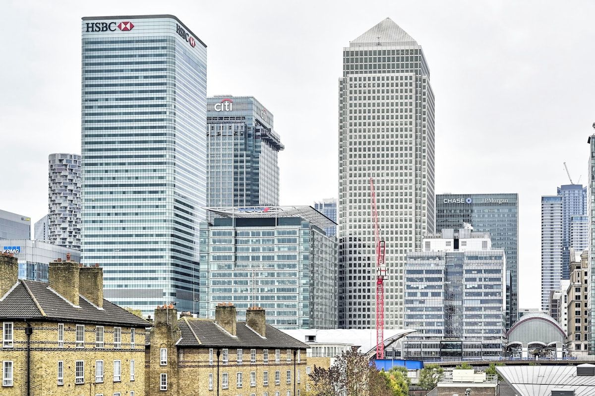 A city skyline with modern high-rise buildings, including recognizable corporate names.
