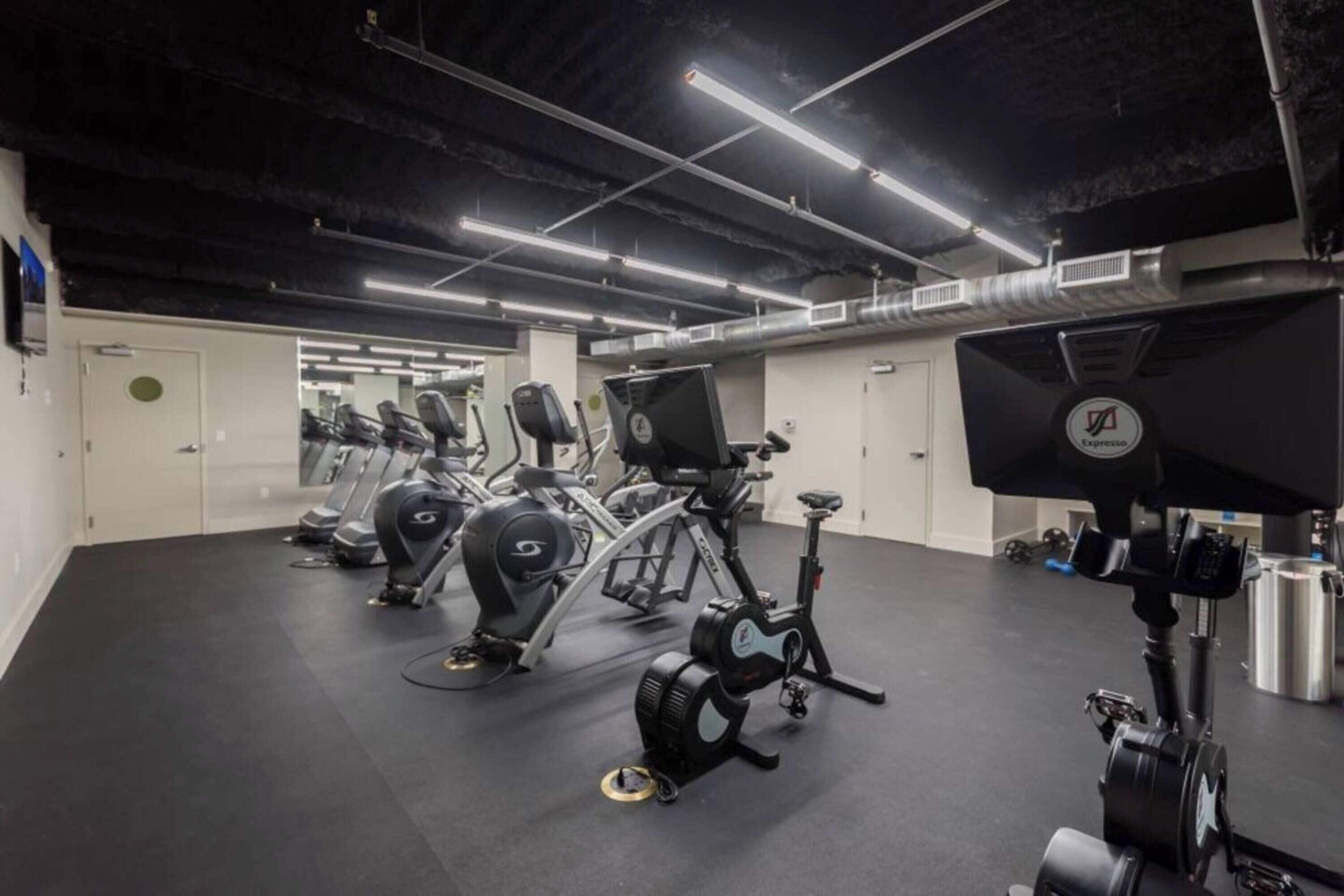 A gym with stationary bikes, treadmills, and exercise equipment.