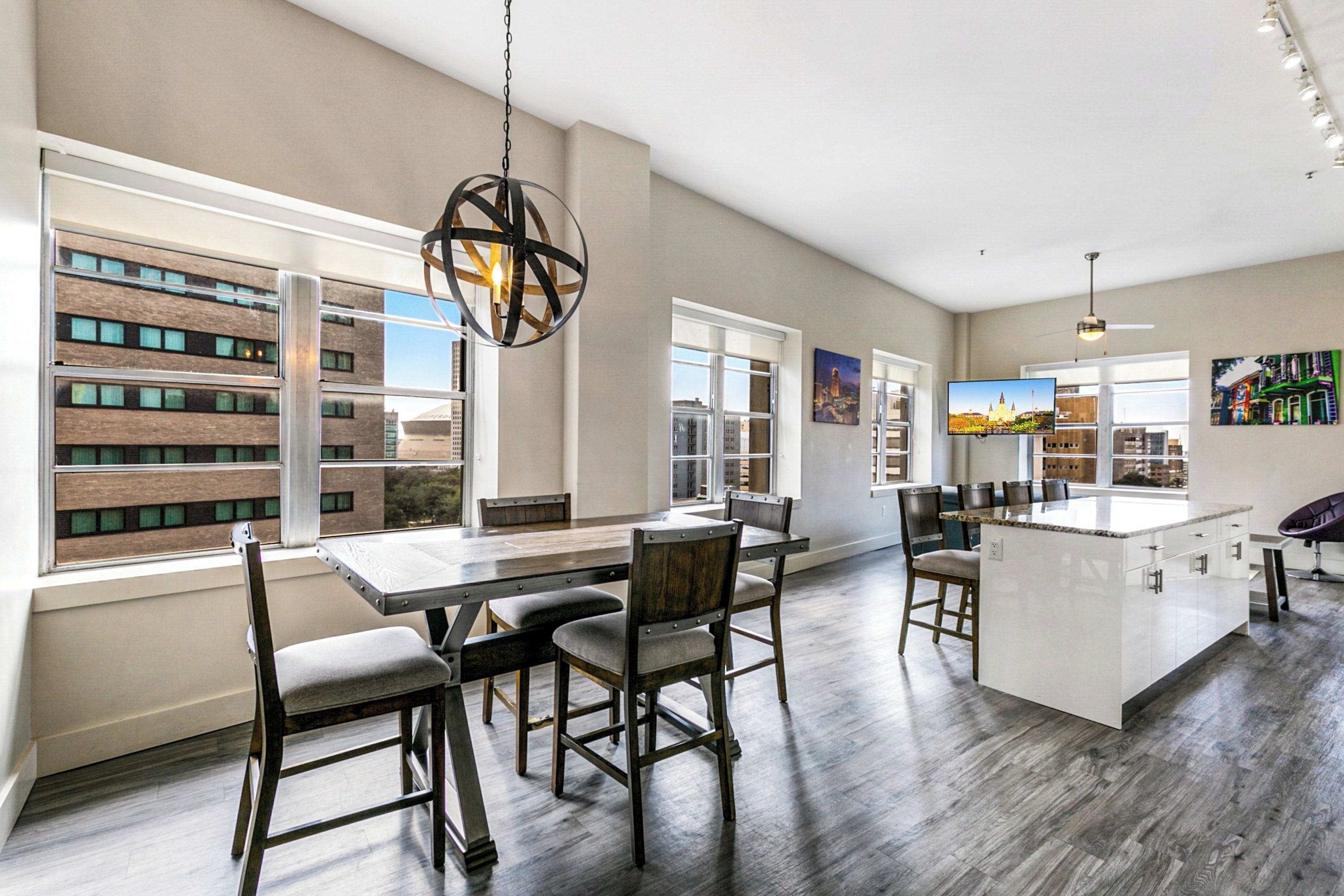 A spacious kitchen with a large island, modern appliances, and large windows offering views of the city.