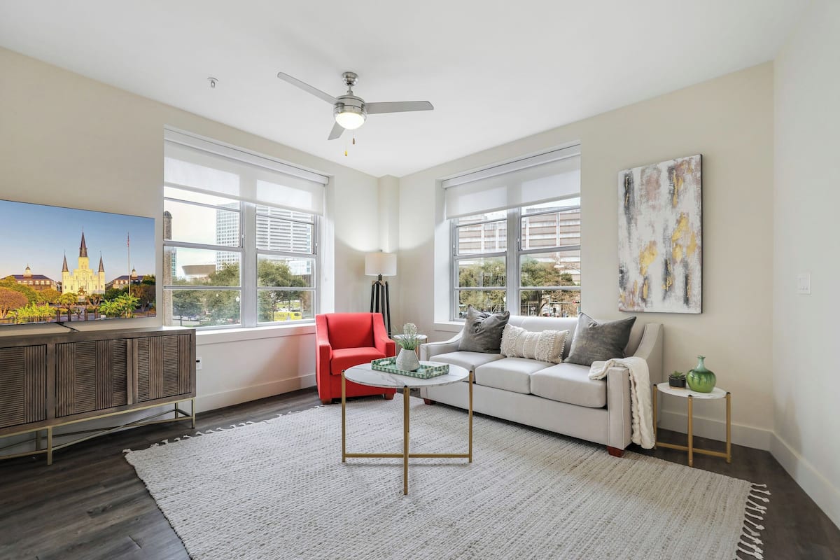 A modern living room with a sofa, red chair, and a coffee table.