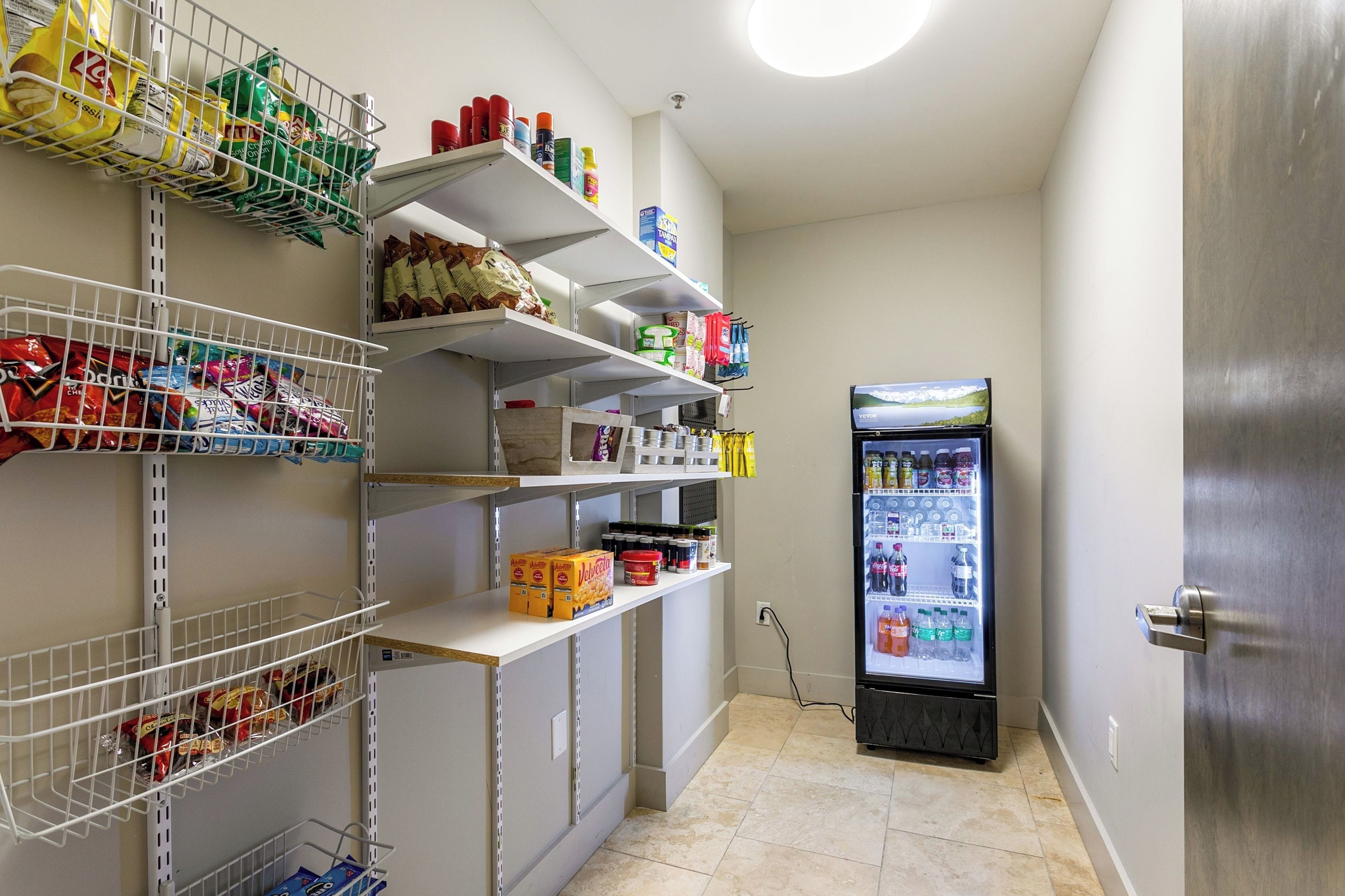A clean, well-organized pantry with shelves stocked with snacks, beverages, and condiments.