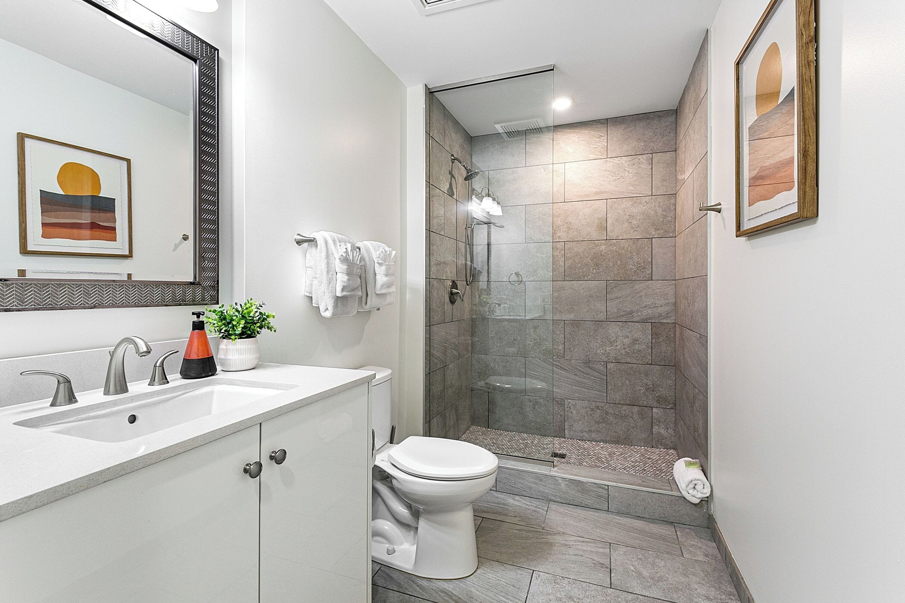 Une salle de bain moderne équipée d’une douche, de toilettes et d’un lavabo.
