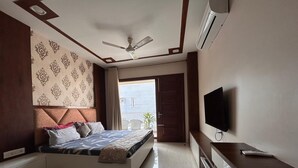Ein modernes Schlafzimmer mit Bett, Fernseher und Deckenventilator.