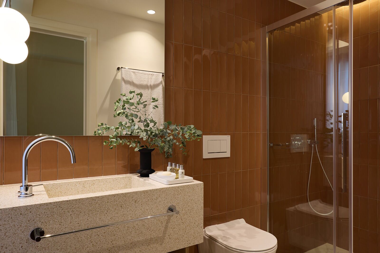 A modern bathroom with a sink, mirror, and shower.