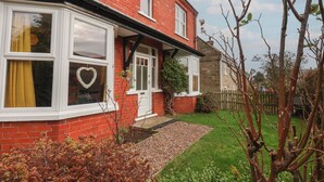 A red brick house with white-framed windows and a heart-shaped decoration on one window. - The Manse (Saltburn-by-the-Sea)