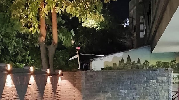 An outdoor swimming pool with a stone wall and metal railings. - The Rabbit Hole Hotel Sok San (Siem Reap)