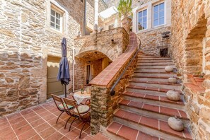 A stone staircase with a table and chairs outside a building.