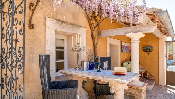 An outdoor patio with a table, chairs, and a hanging flower arrangement. - Gite Bleu - Paradise of Provence (Le Pin)