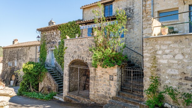 A stone building with a staircase, a gate, and a small balcony with a potted plant. - Holiday Home 'Orange - Paradis De Provence' with Mountain View, Private Terrace and Wi-Fi (Verfeuil)