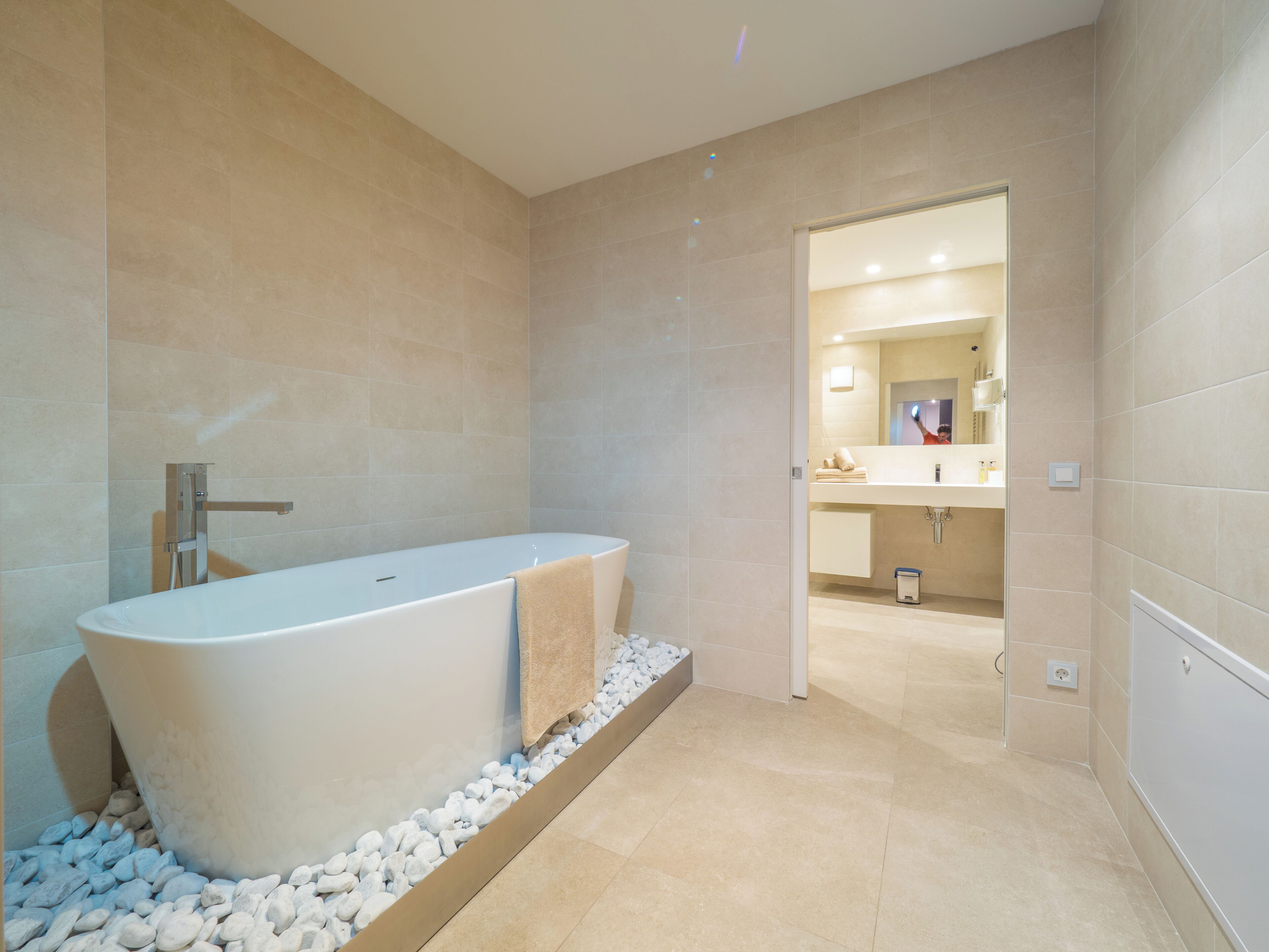 A modern bathroom with a freestanding bathtub, a shower area, and a vanity with a mirror.