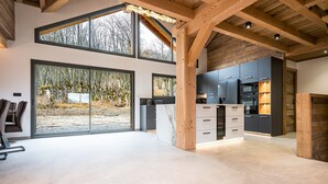 Una cocina amplia con ventanas grandes, vigas de madera y muebles de cocina modernos.