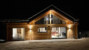Una casa de madera con ventanas amplias y un balcón.