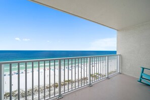 Ein Balkon mit Blick auf Strand und Meer.