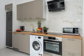 Departamento Confort, vista a la ciudad | Cocina privada | Refrigerador, microondas, horno y parrilla de estufa 