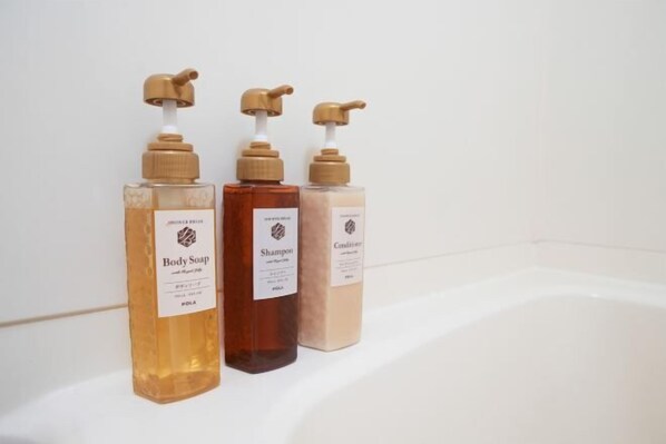 Tres botellas de jabón de baño sobre una superficie blanca.