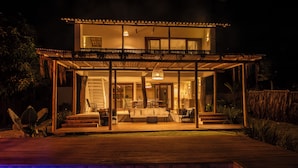 A two-story house with a covered patio and a swimming pool. - Casinha Praia do Espelho (Porto Seguro)
