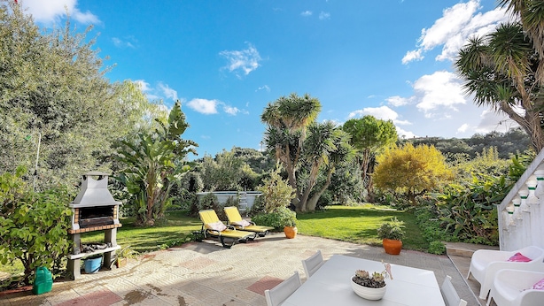 Une terrasse avec un barbecue, des sièges d’extérieur et une table.