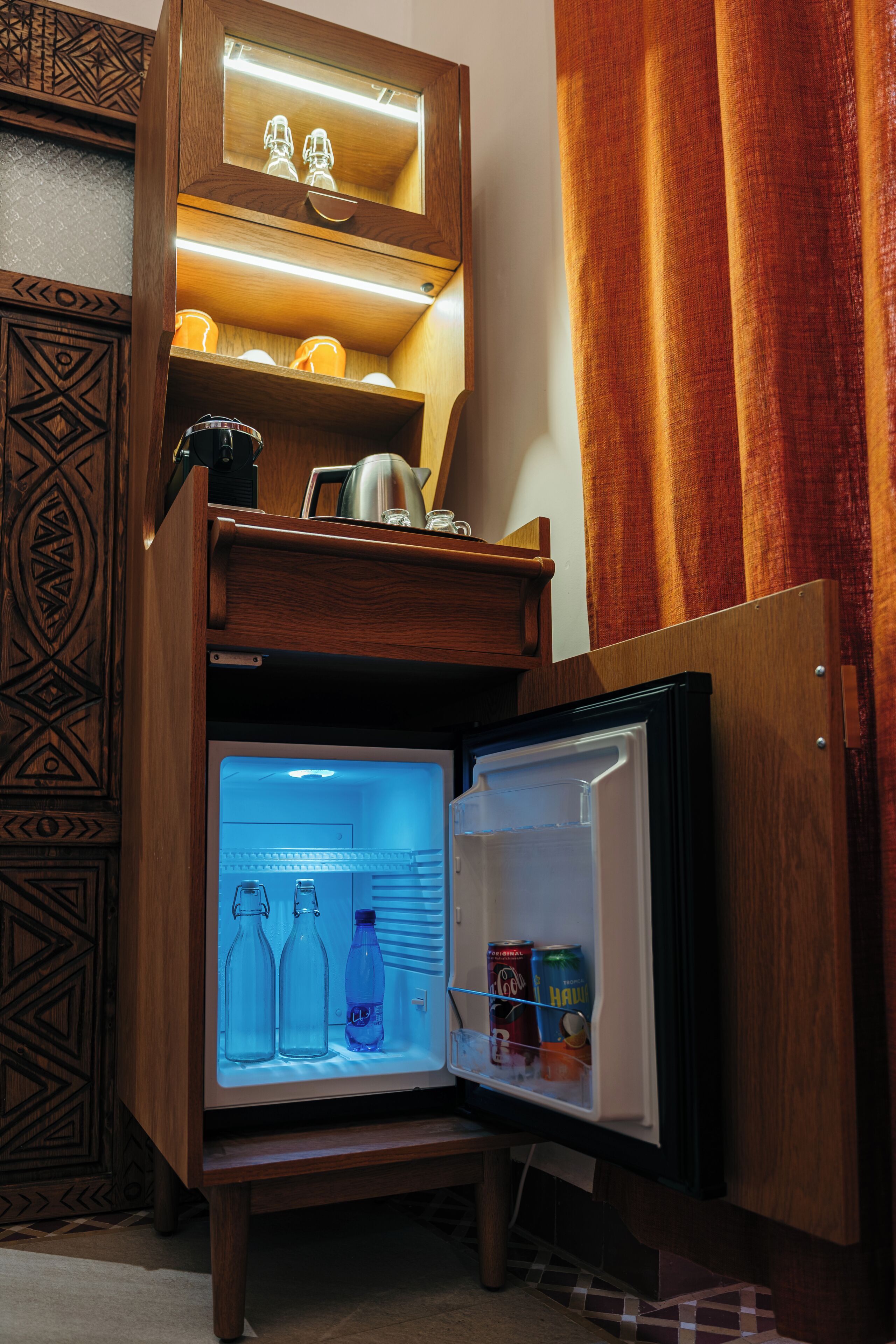 A compact refrigerator with a built-in microwave, a small shelf, and a freezer compartment.