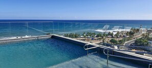 Une piscine offrant une vue dégagée sur l’océan et un phare visible au loin.