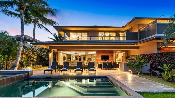 A modern two-story house with a swimming pool, outdoor seating, and a well-maintained garden.