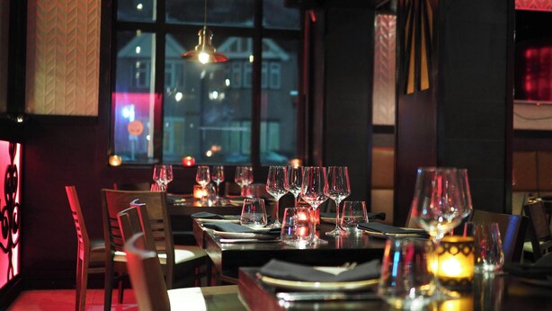 A restaurant with tables set for dining, glasses, and candles. - Igitego Hotels (Kigali)