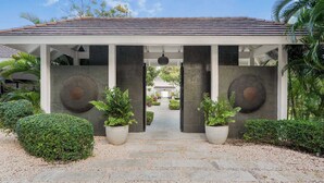 A modern building with a covered entrance, stone columns, and potted plants.