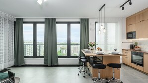 A modern kitchen with a dining area, large windows, and a view of the city. - Lumina 15th Floor Apartment in Warsaw  (Warsaw)