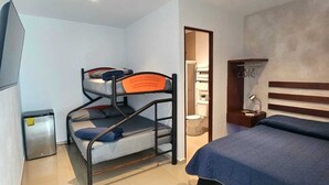A compact hotel room with bunk beds, a small bedside table, a mirror, and a TV. - Villa Leo Room with bunk bed ideal for families, in the heart of Cancun (Cancun)